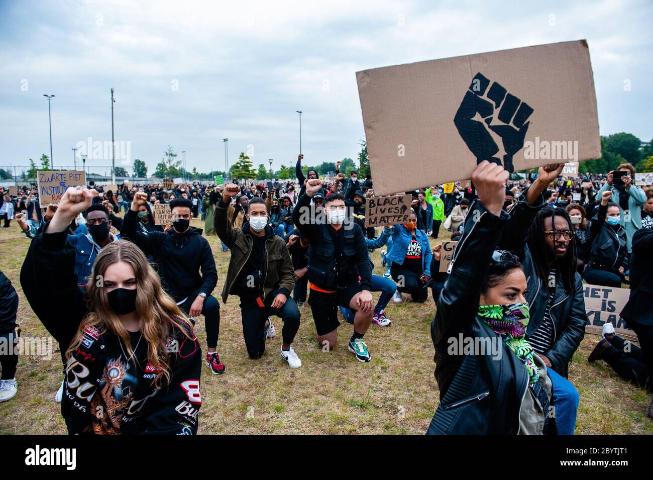 Protesters take a knee during the demonstration.Thousands of people gathered at the Nelson Mandela Park to protest against police brutality and racism which is an initiative of residents of the Bijlmer district, the largest population of Afro-Dutch people in Amsterdam. The black community has been a victim of oppression for decades since the 1990s. Stock Photo