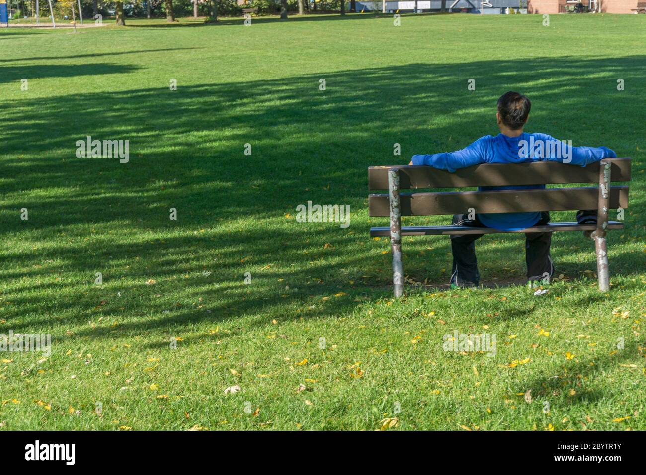 Back of man alone on park bench hi-res stock photography and images - Alamy