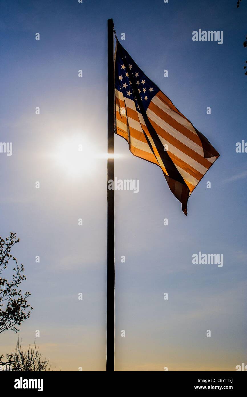 American flag back-lit by sun on flagpole Stock Photo