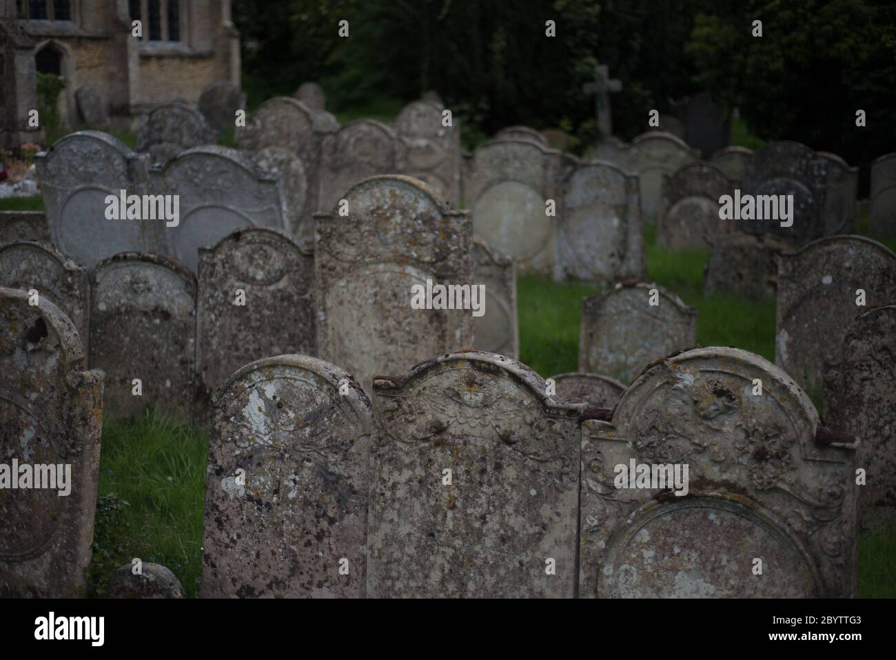 packed cemetery with old decaying gravestones in church churchyard Stock Photo