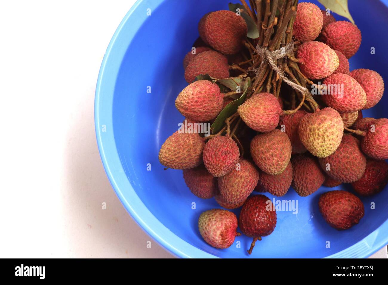 Fresh red litchi, lichee, lychee, or litchi in a colorful bowl, close up photography Stock Photo