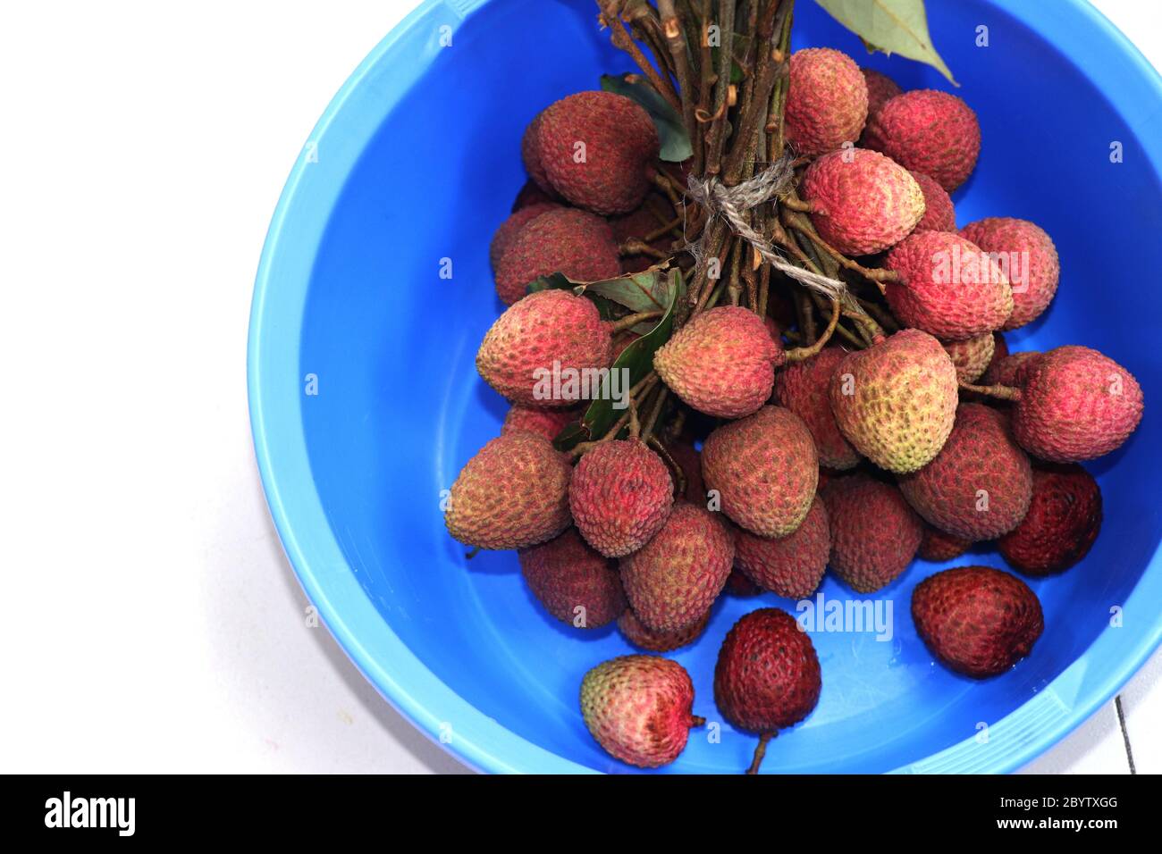 Fresh red litchi, lichee, lychee, or litchi in a colorful bowl, close up photography Stock Photo