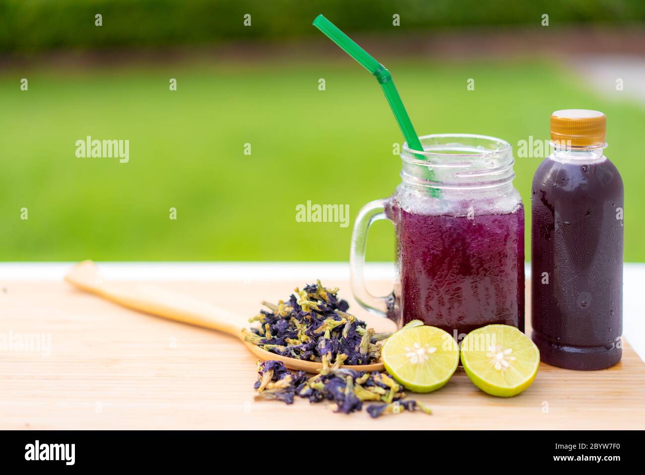 Butterfly pea flower herbal  and dry butterfly pea flower on wooden table Thai herb juice and refreshment cold drink. Stock Photo