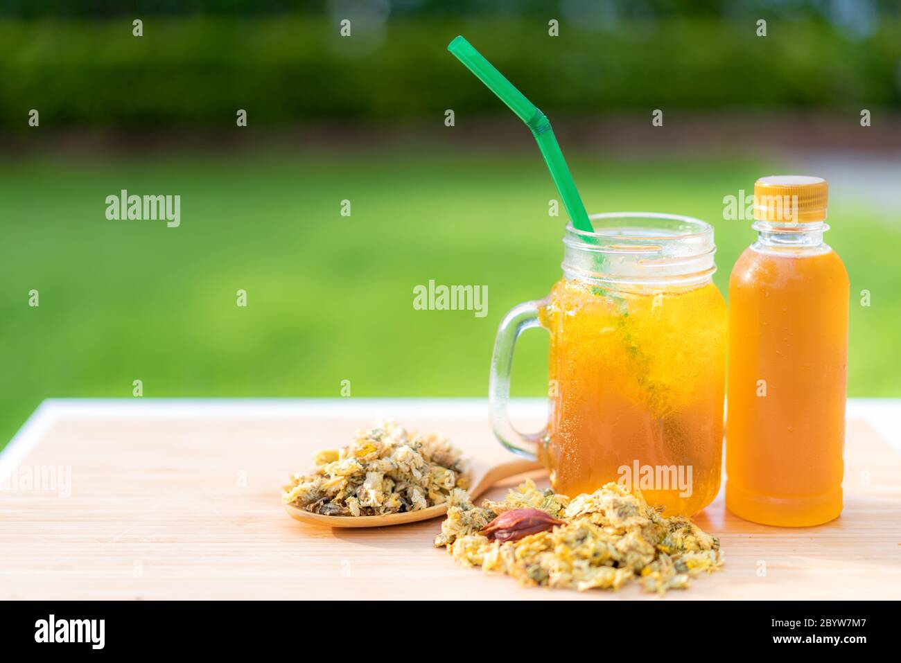 Cold water of chrysanthemum flowers and dried chrysanthemum flowers on wooden table chinese Thai herb juice and refreshment cold drink. Stock Photo