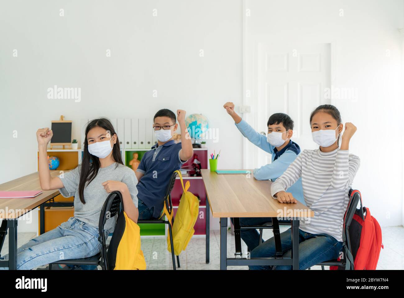 Group of Asian elementary school students wearing hygienic mask in ...