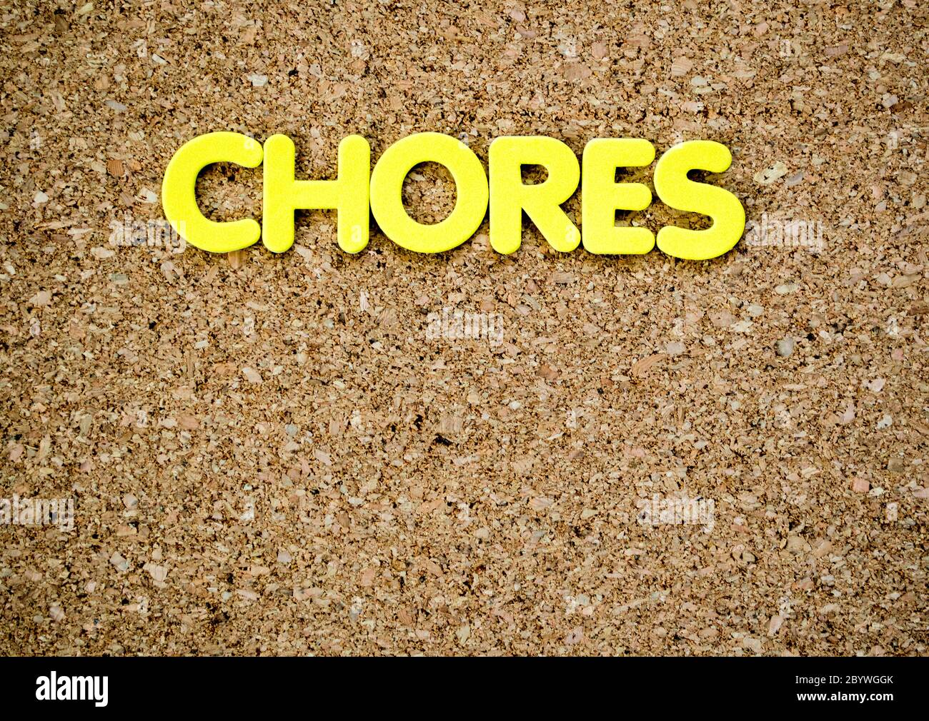 an empty brown cork board with the word 'CHORES' at the top in yellow