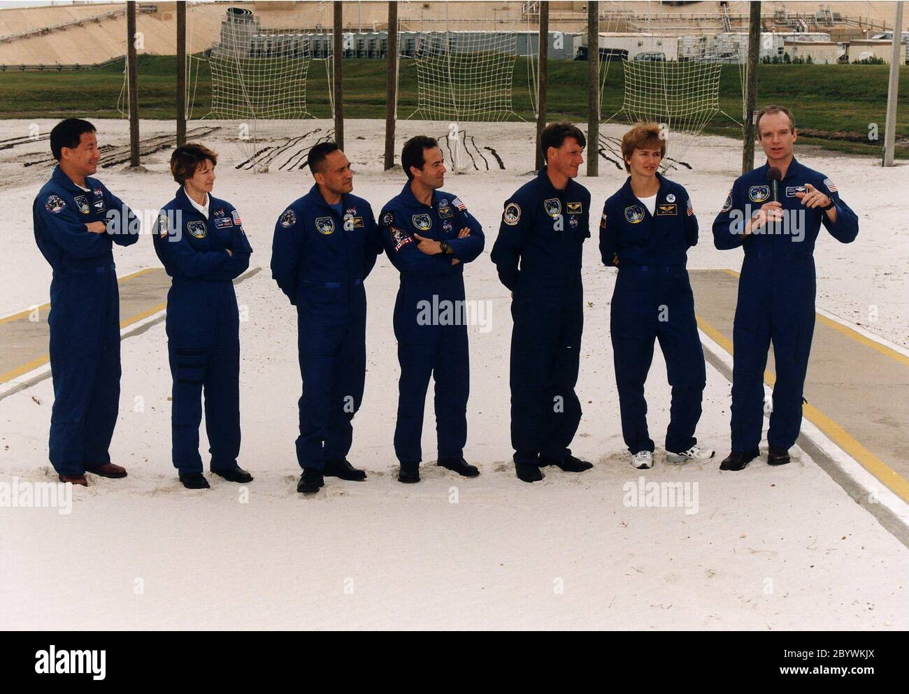 STS-84 crew members listen intently to Commander Charles J. Precourt, at far right, as he talks to news media representatives and other onlookers at Launch Pad 39A during the Terminal Countdown Demonstration Test (TCDT). Other crew members, from left, are Mission Specialist Edward Tsang Lu, Pilot Eileen Marie Collins, and Mission Specialists Carlos I. Noriega, Jean-Francois Clervoy of the European Space Agency, C. Michael Foale, and Elena V. Kondakova of the Russian Space Agency. STS-84 will be the sixth docking of the Space Shuttle with the Russian Space Station Mir. After docking, Foale will Stock Photo