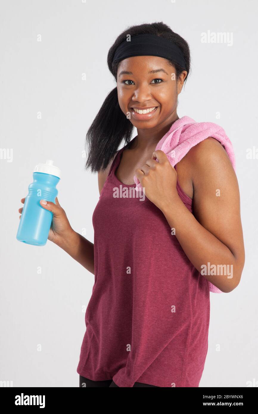 Happy Black woman with a towel and water bottle for her workout Stock ...