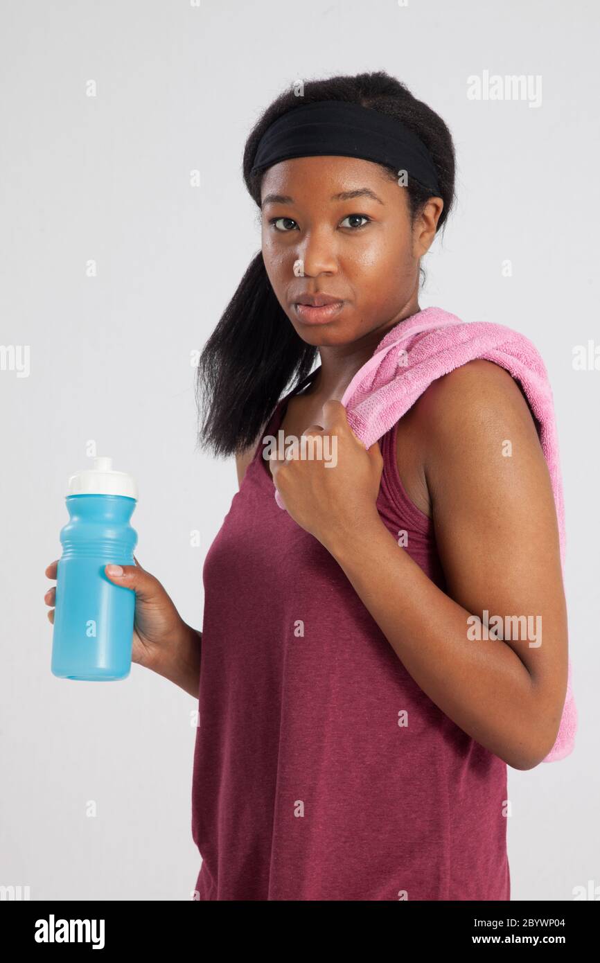 Lovely Black woman with exercise towel and water bottle Stock Photo - Alamy