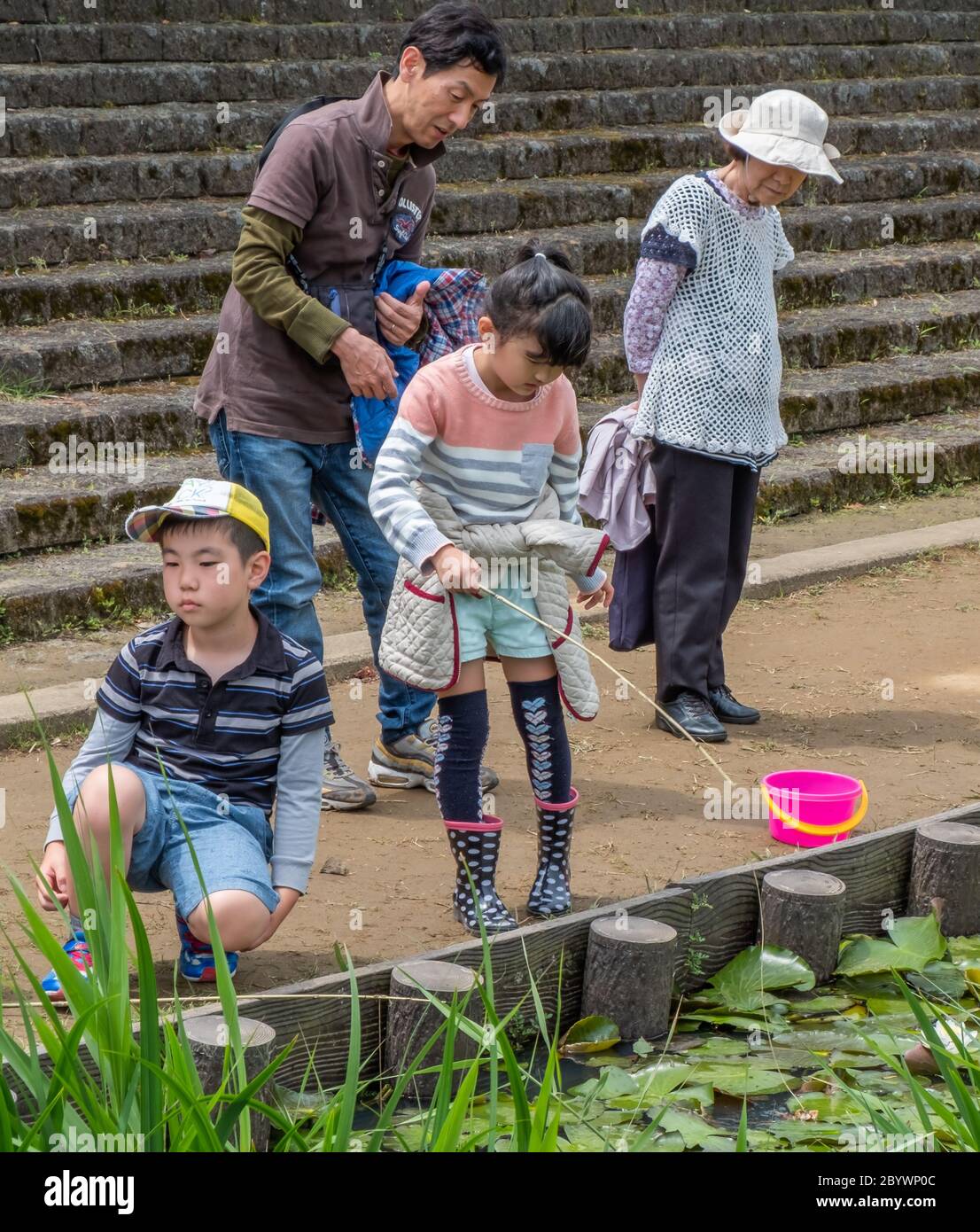 Children and family enjoying fishing in a pond during Suigo Itako Iris Festival, Ibaraki, Japan Stock Photo
