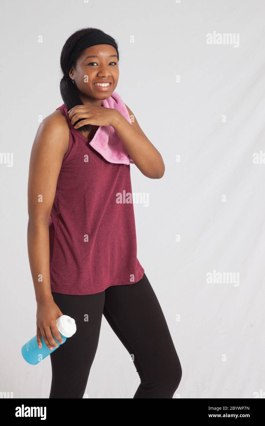 Happy Black woman with a towel and water bottle for her workout Stock ...