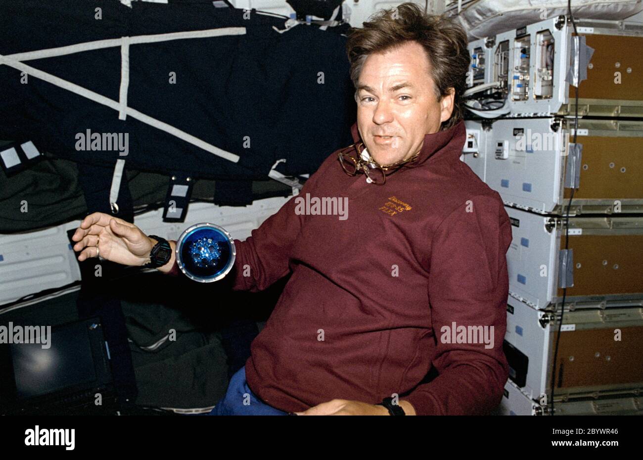 (7 - 19 August 1997) --- Payload specialist Bjarni Tryggvason of the Canadian Space Agency (CSA) shows off the Microgravity Vibration Isolation Mount (MIM) fluid disk.  One of five fluid loop experiments (FLEX), this one deals with the growth of resonance patterns (GORP) in gaseous liquid systems. Stock Photo