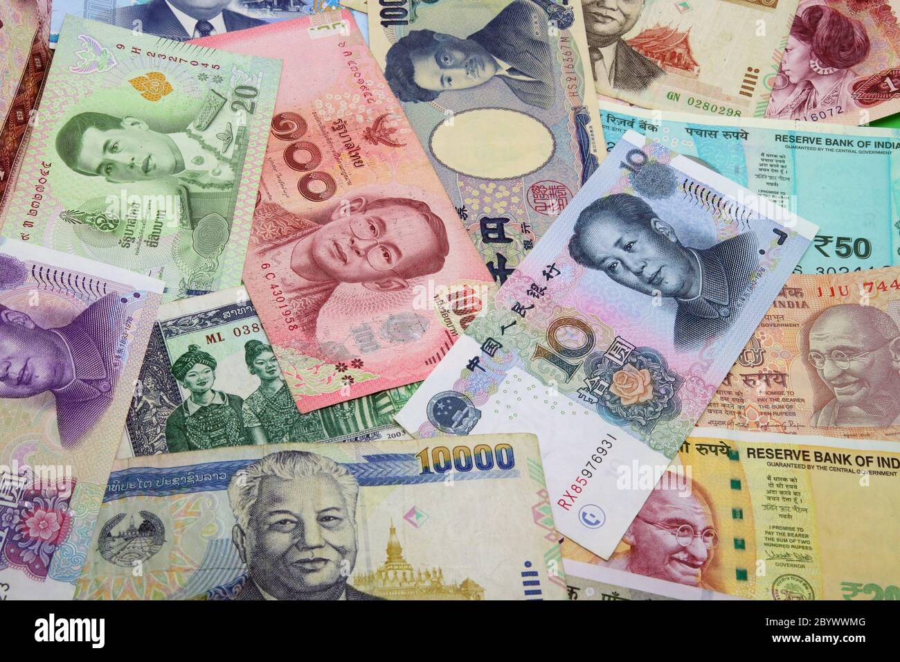 Mix of Chinese, Indian, Japanese, Lao and Thai colorful banknotes close ...