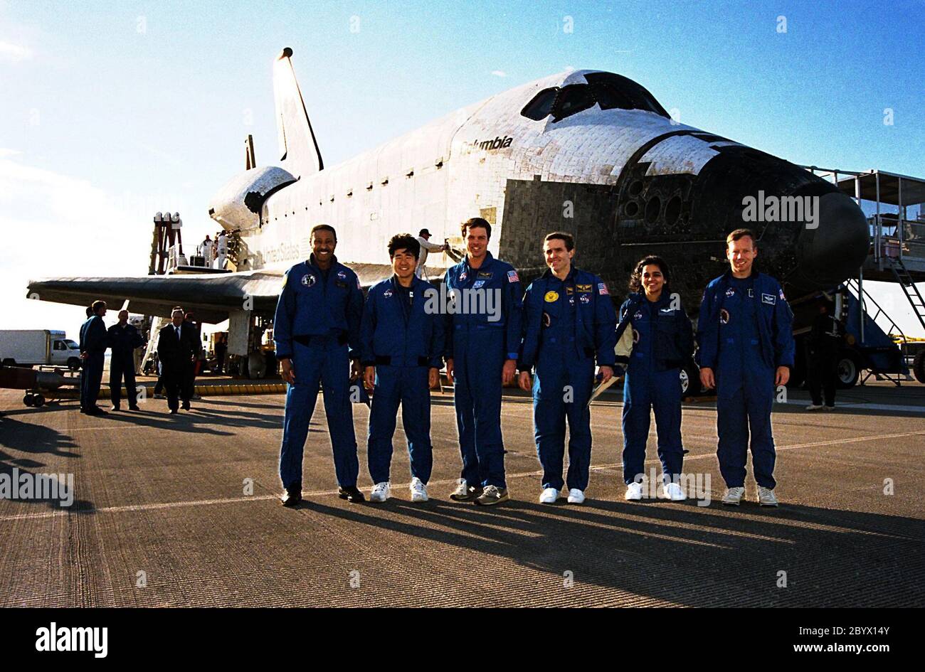 The STS-87 crew pose in front of the orbiter Columbia shortly after landing on Runway 33 at KSC's Shuttle Landing Facility. STS-87 concluded its mission with a main gear touchdown at 7:20:04 a.m. EST Dec. 5, drawing the 15-day, 16-hour and 34-minute-long mission of 6.5 million miles to a close. From left to right are Mission Specialists Winston Scott and Takao Doi, Ph.D., of the National Space Development Agency of Japan; Commander Kevin Kregel; Payload Specialist Leonid Kadenyuk of the National Space Agency of Ukraine; Mission Specialist Kalpana Chawla, Ph.D.; and Pilot Steven Lindsey. During Stock Photo
