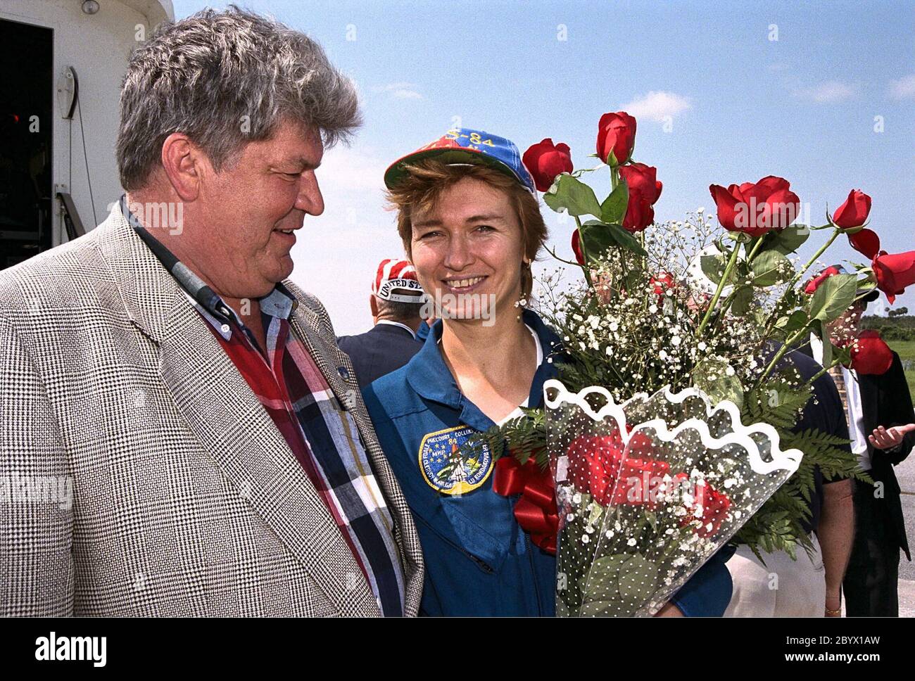 Veteran cosmonaut Valery Ryumin greets his wife, STS-84 Mission Specialist Elena V. Kondakova, with some flowers after the Space Shuttle orbiter Atlantis lands on KSC’s Runway 33. STS-84 was the sixth docking of the Space Shuttle with the Russian Space Station Mir. The nine-day STS-84 mission was Kondakova’s second space flight, but her first on the Space Shuttle. She spent 169 days in space as flight engineer of the 17th main mission on Mir from October 1994 to March 1995. Her husband is now director of the Mir-Shuttle program for Russia Stock Photo