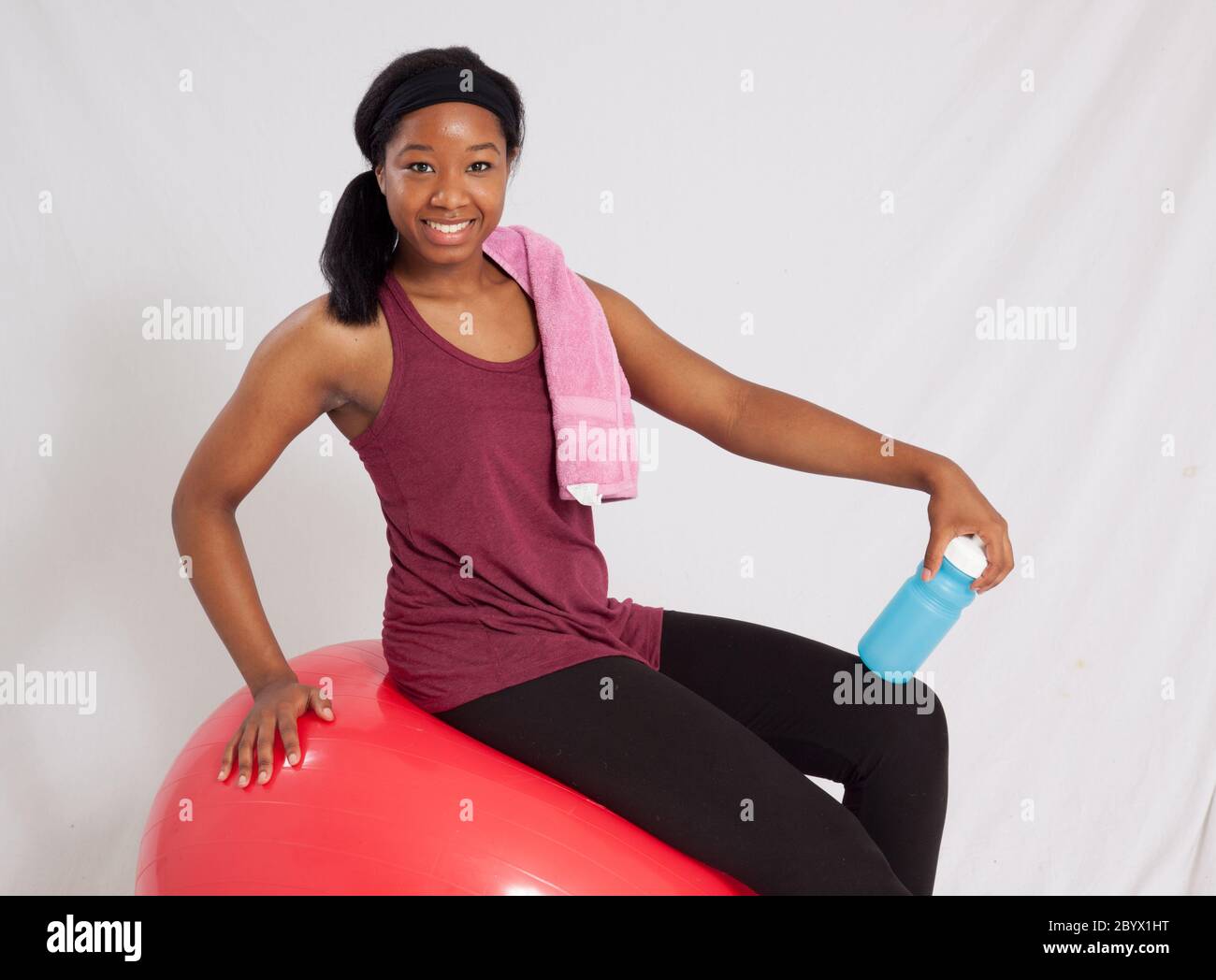 Pretty black woman with exercise ball, towel and water bottle Stock ...