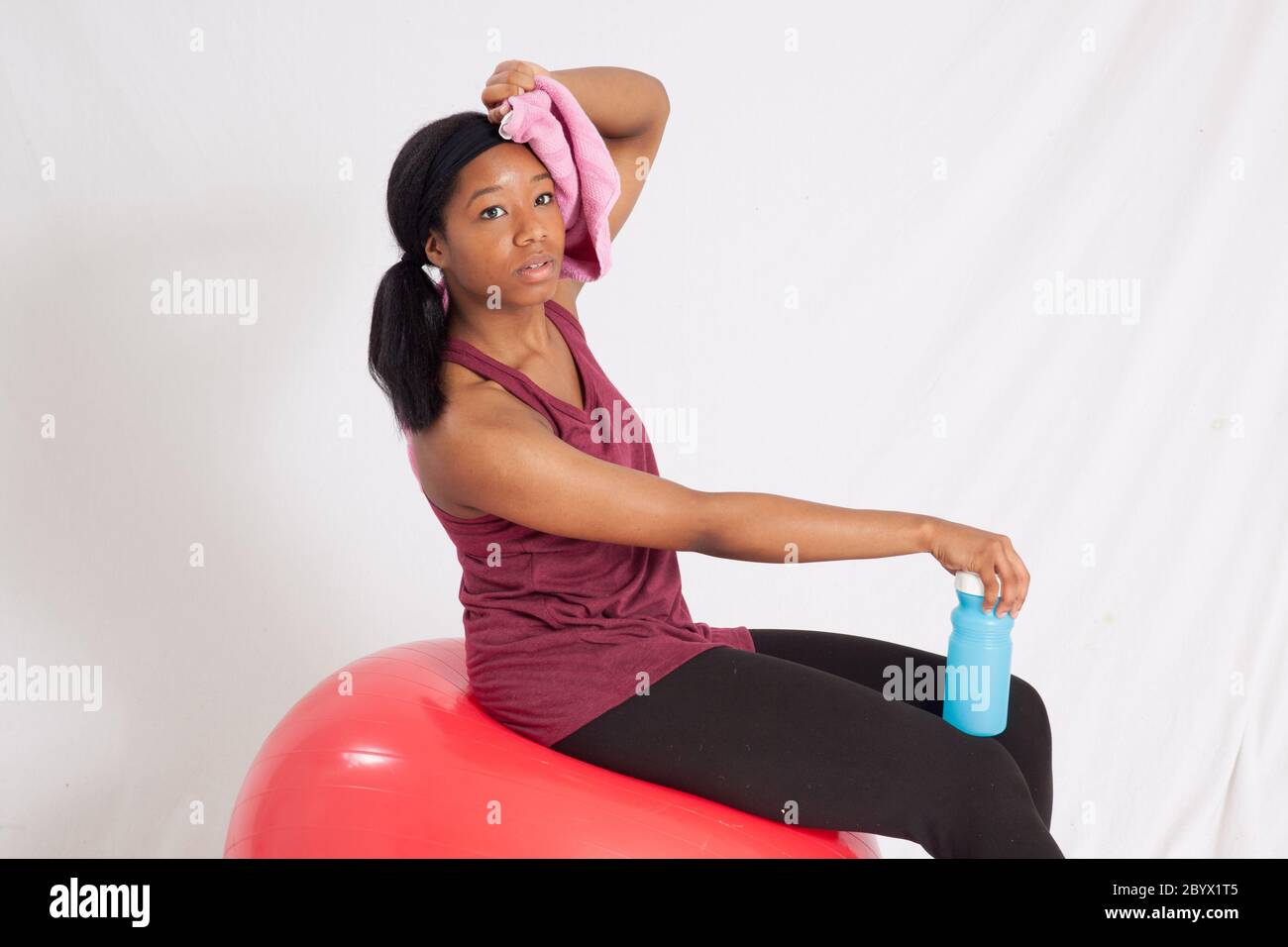 Pretty black woman with exercise ball, towel and water bottle Stock ...