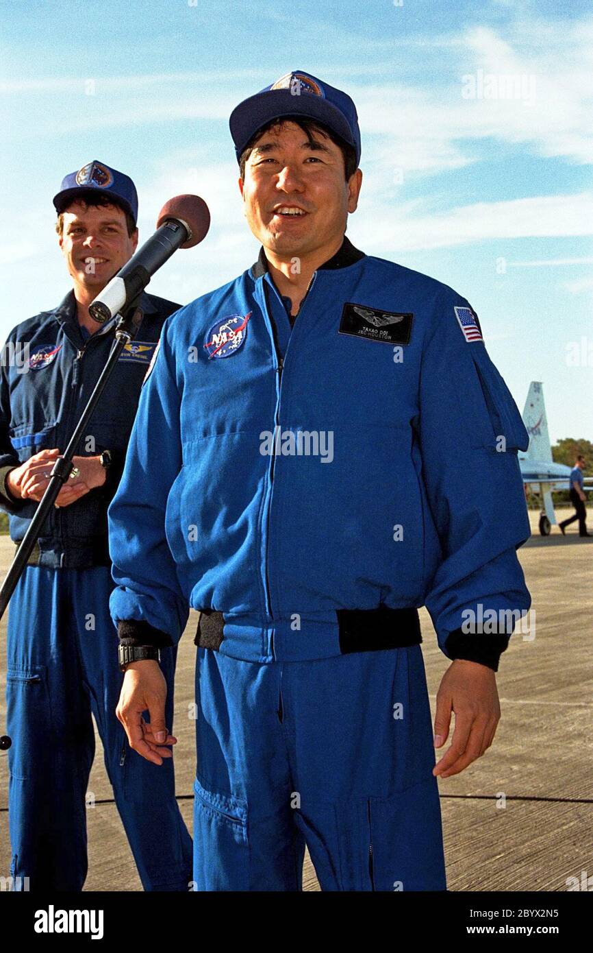 As STS-87 Commander Kevin Kregel looks on, Mission Specialist Takao Doi, Ph.D., of the National Space Development Agency of Japan addresses members of the press and media at Kennedy Space Center's Shuttle Landing Facility after arriving for the final prelaunch activities leading up to the scheduled Nov. 19 liftoff. Other STS-87 crew members not pictured are Pilot Steven Lindsey; Mission Specialists Kalpana Chawla, Ph.D., and Winston Scott; and Payload Specialist Leonid Kadenyuk of the National Space Agency of Ukraine. STS-87 will be the fourth flight of the United States Microgravity Payload a Stock Photo
