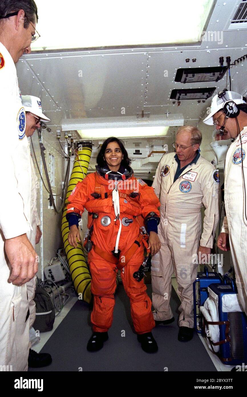 STS-87 Mission Specialist Kalpana Chawla, Ph.D., is assisted with her orange launch and entry spacesuit by NASA suit technicians at Launch Pad 39B during Terminal Countdown Demonstration Test (TCDT) activities. The crew of the STS-87 mission is scheduled for launch Nov. 19 aboard the Space Shuttle Columbia. The TCDT is held at KSC prior to each Space Shuttle flight providing the crew of each mission opportunities to participate in simulated countdown activities. The TCDT ends with a mock launch countdown culminating in a simulated main engine cut-off. The crew also spends time undergoing emerg Stock Photo