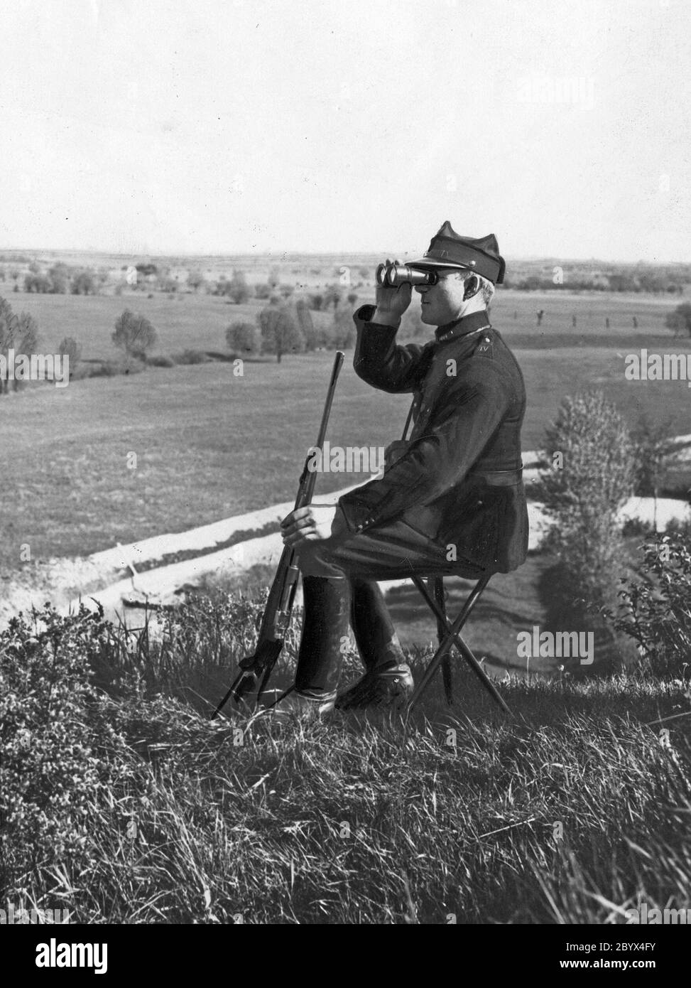 A customs guard officer observes the area through binoculars ca. 1923-1928 Stock Photo