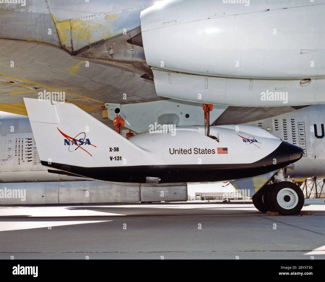 A close-up view of the X-38 research vehicle mounted under the wing of the B-52 mothership prior to a 1997 test flight. The X-38, which was designed to help develop technology for an emergency crew return vehicle (CRV) for the International Space Station, is one of many research vehicles the B-52 has carried aloft over the past 40 years. Stock Photo