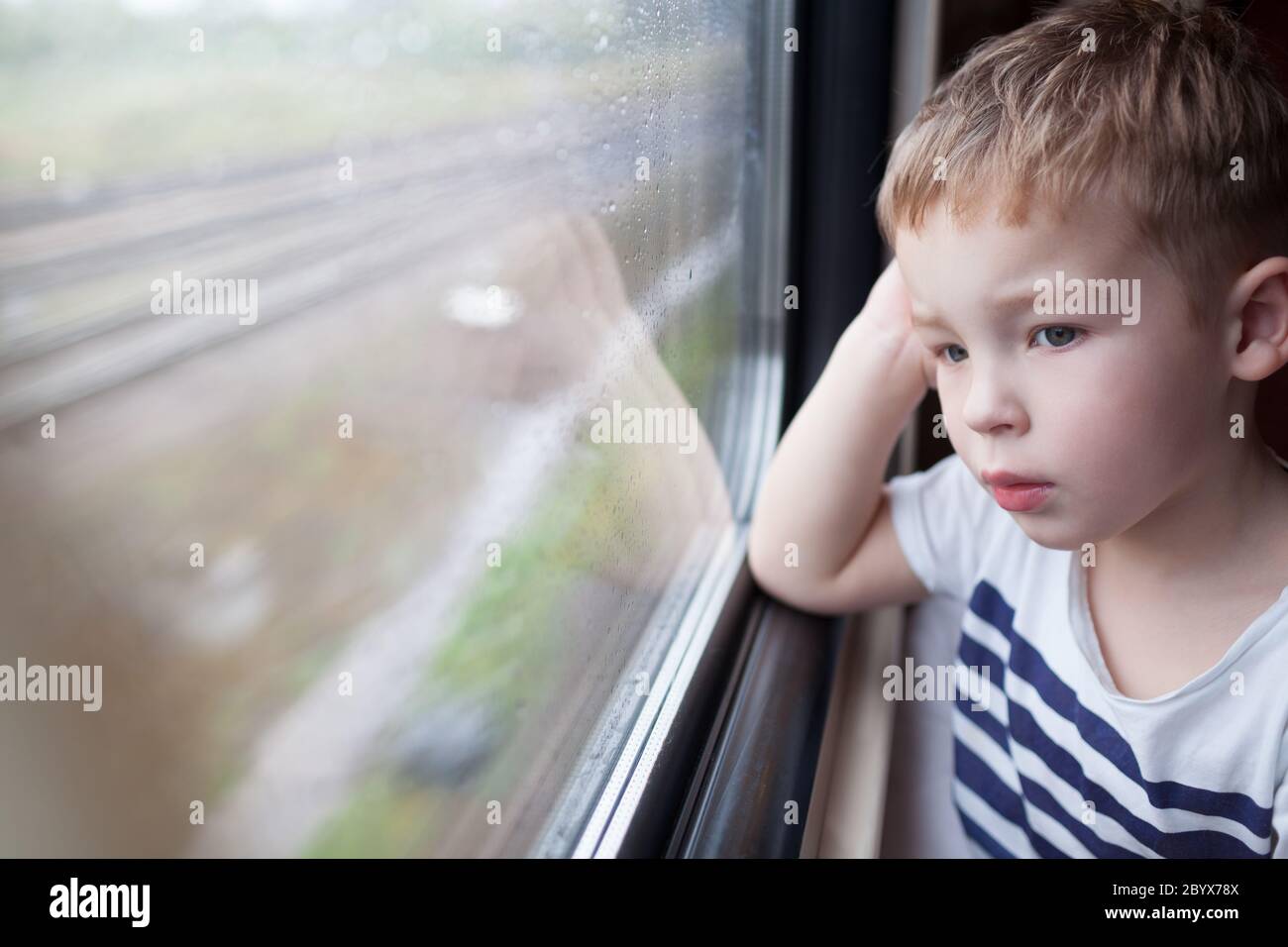 Boy looking out the window of train Stock Photo