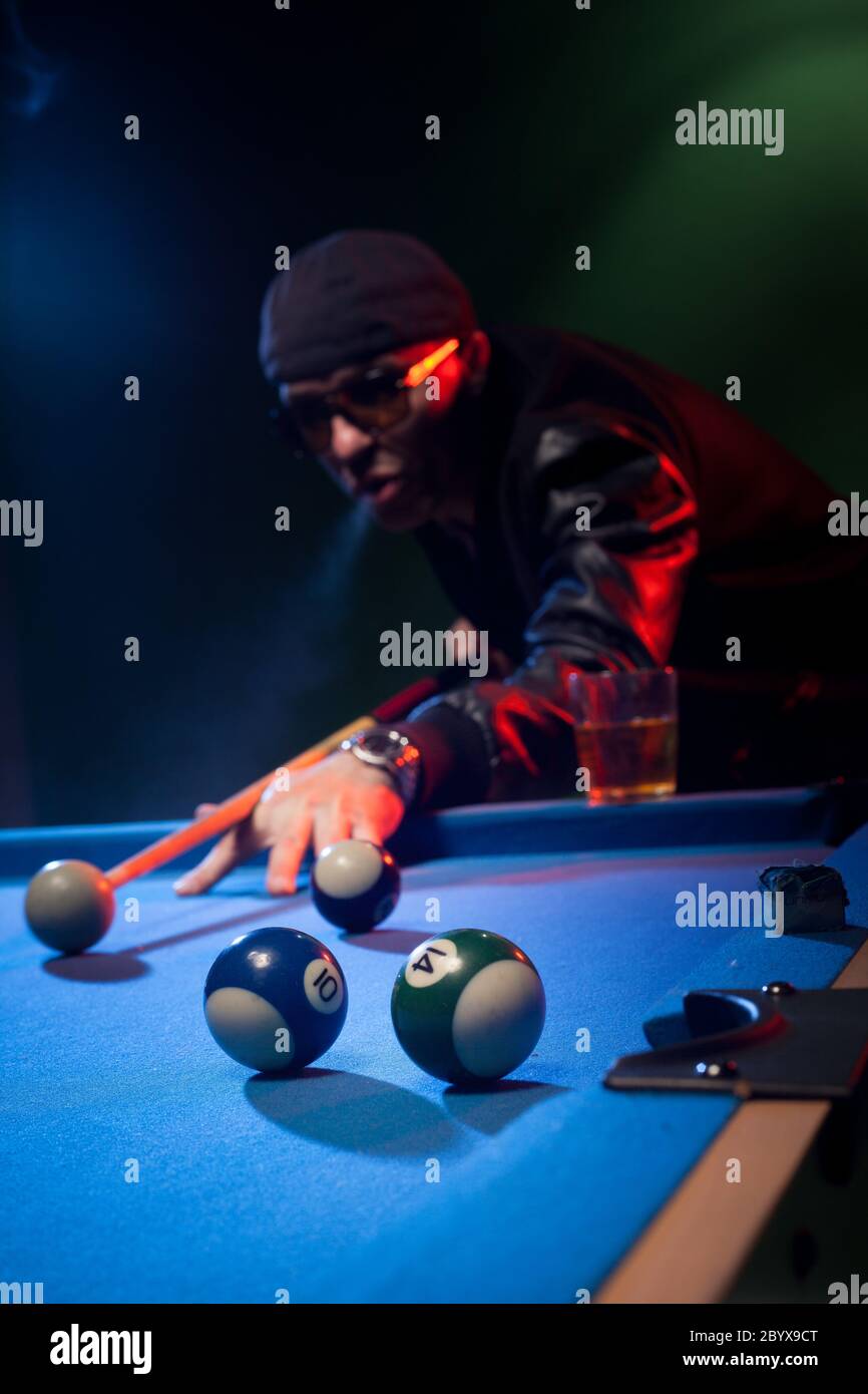 Man playing pool lining up on the cue ball Stock Photo