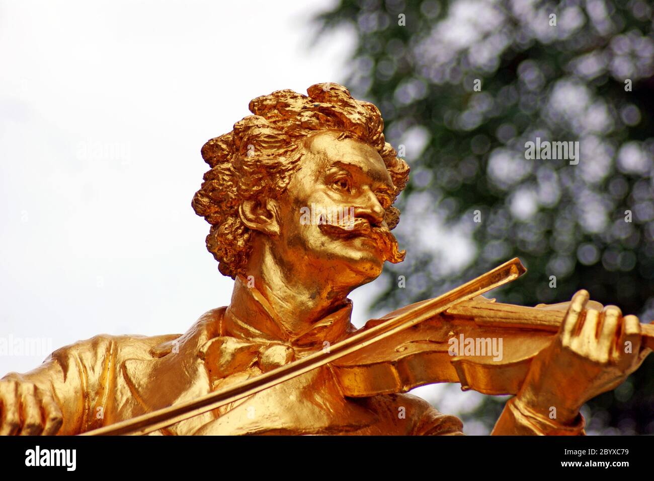 Gold-gilded bronze statue of Johann Strauss playing a violin in the Stadtpark in Vienna, Austria. Stock Photo