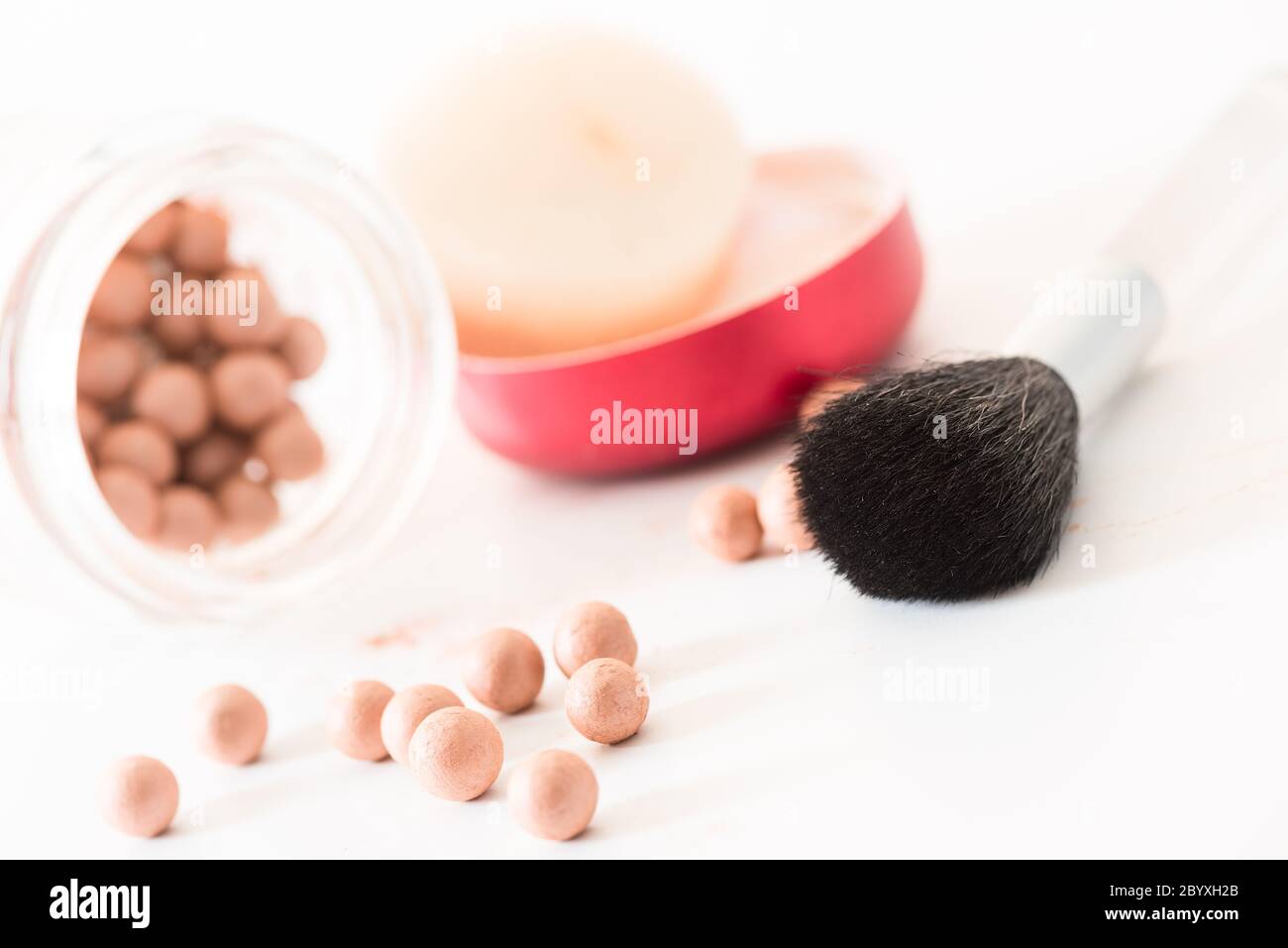 Composition of bronzing pearls and makeup brush angled Stock Photo Alamy