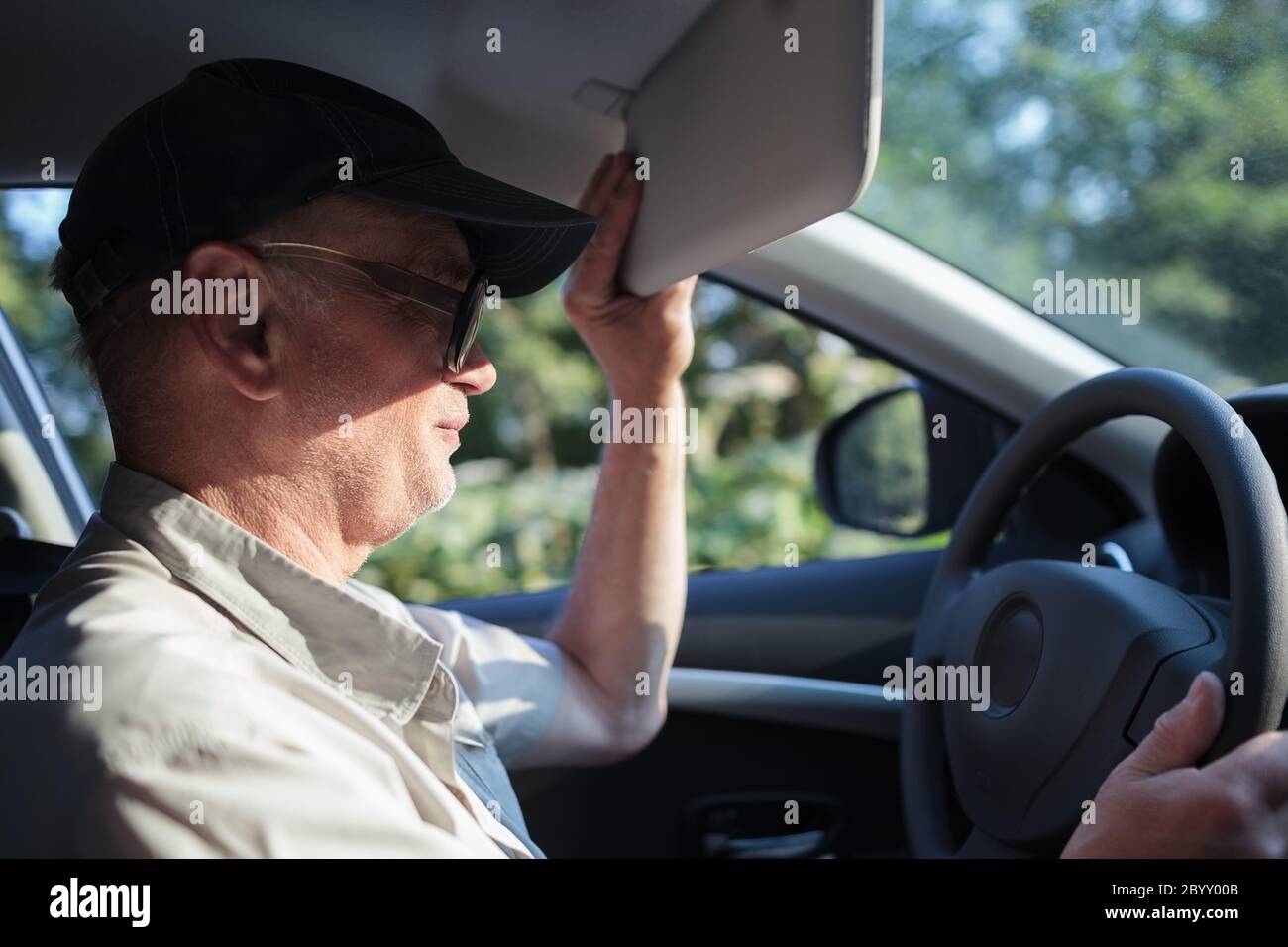 Senior driver hiding from the sun Stock Photo