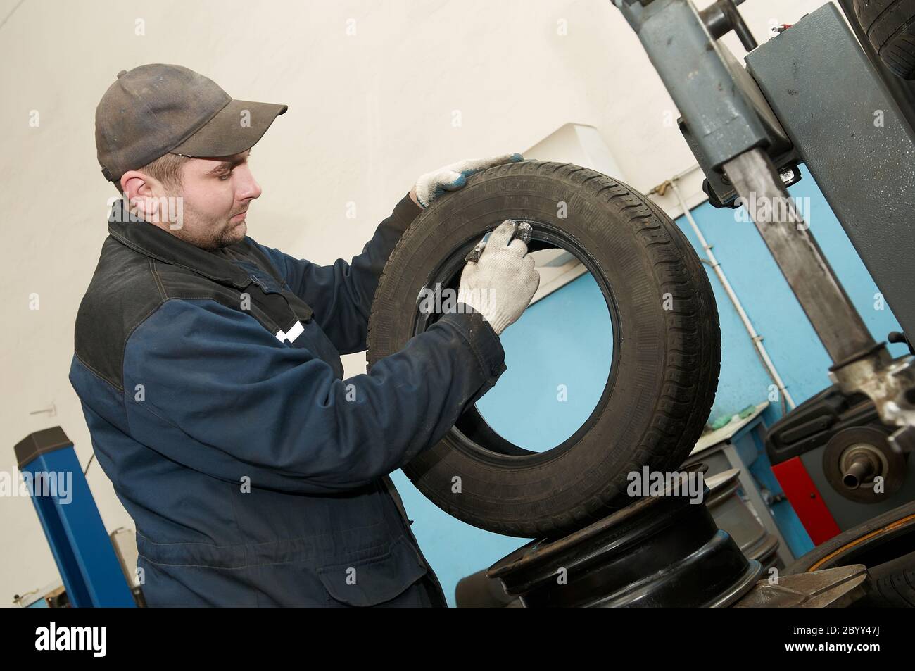 repairman lubricating car tyre Stock Photo