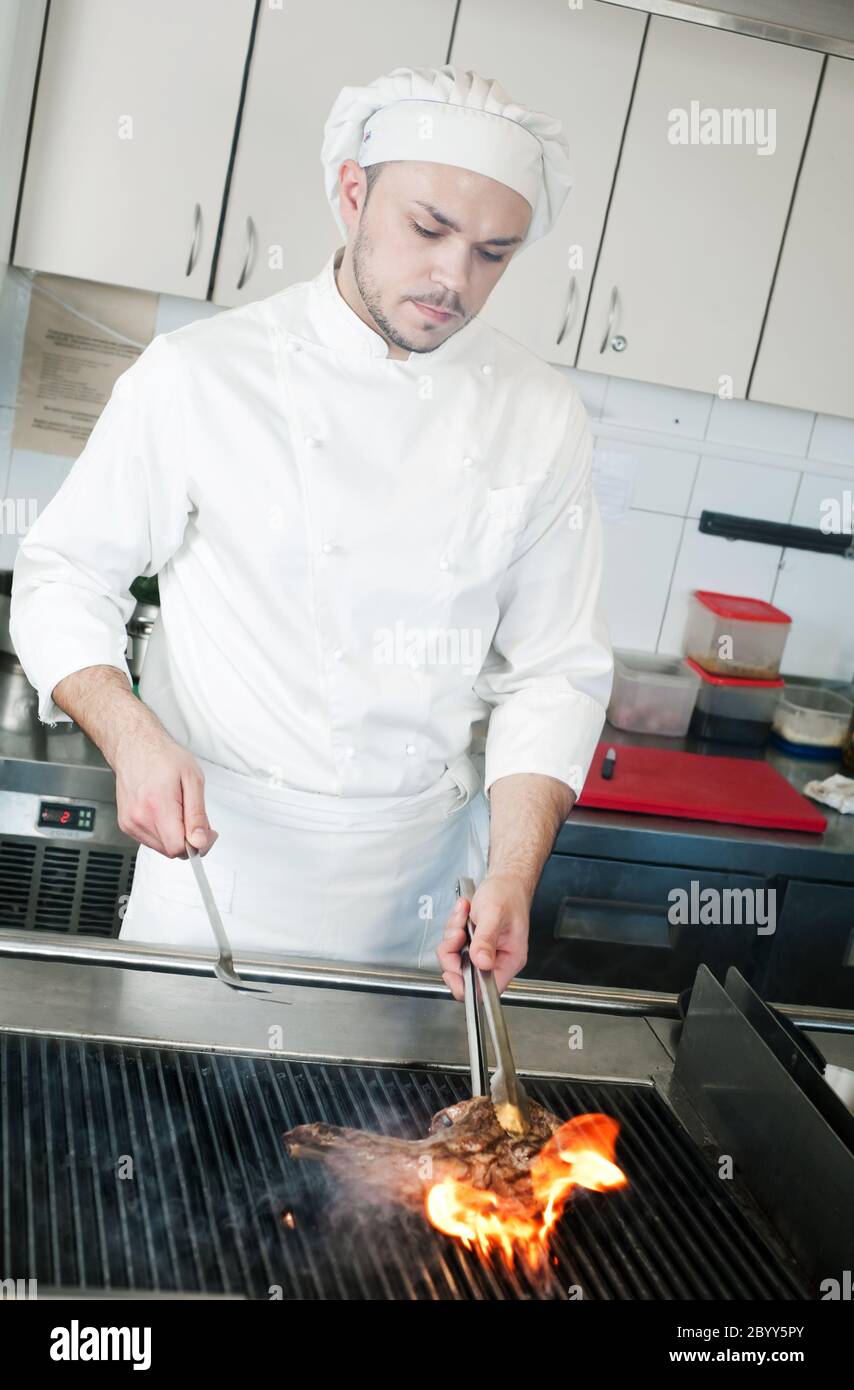 chef frying beef steak on grill with fire Stock Photo - Alamy