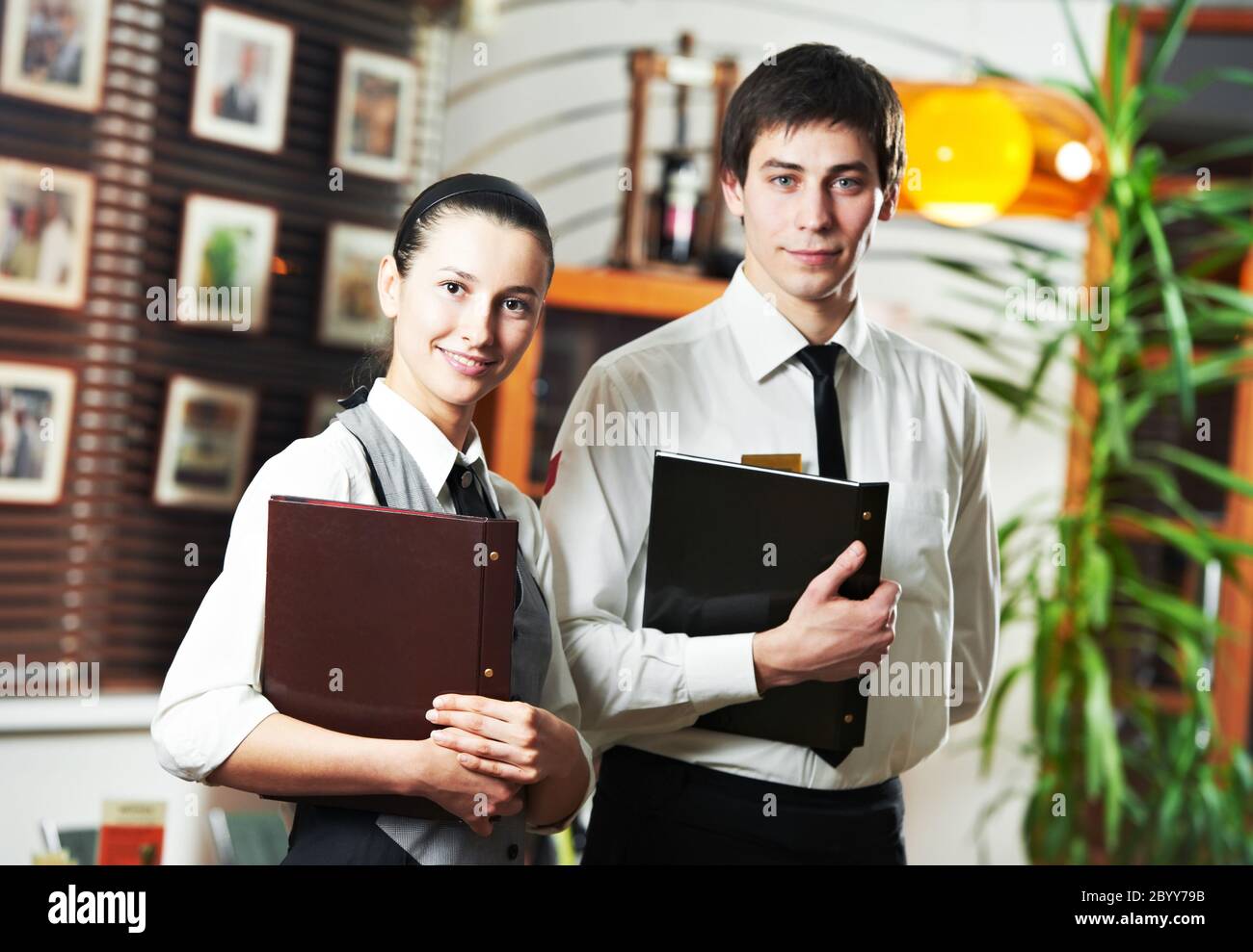 Waitress girl and waiter man in restaurant Stock Photo