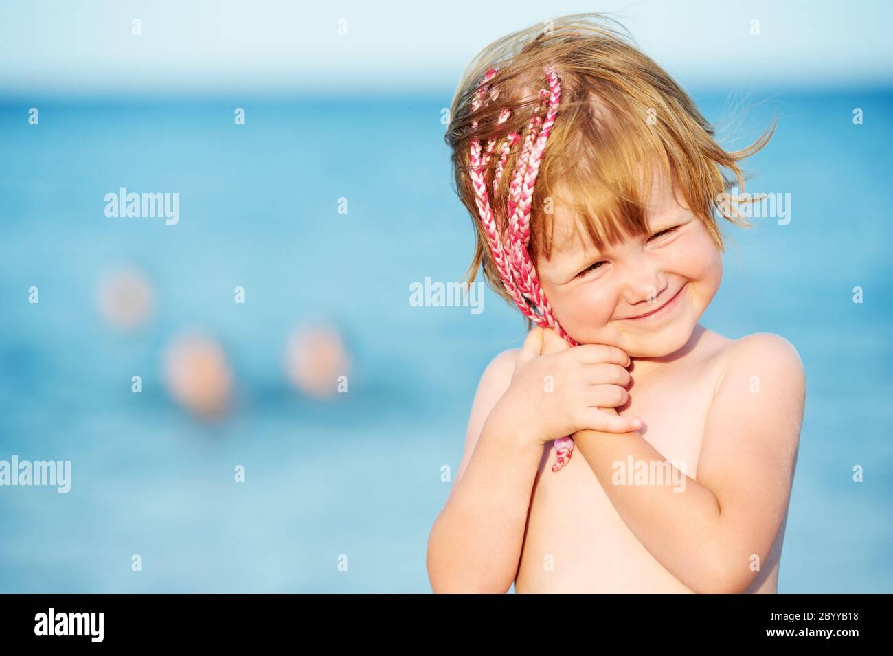 little girl at sunset in front of red sea Stock Photo