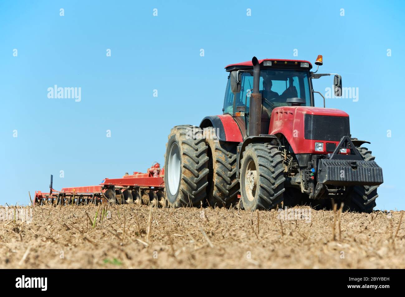 Ploughing tractor at field cultivation work Stock Photo