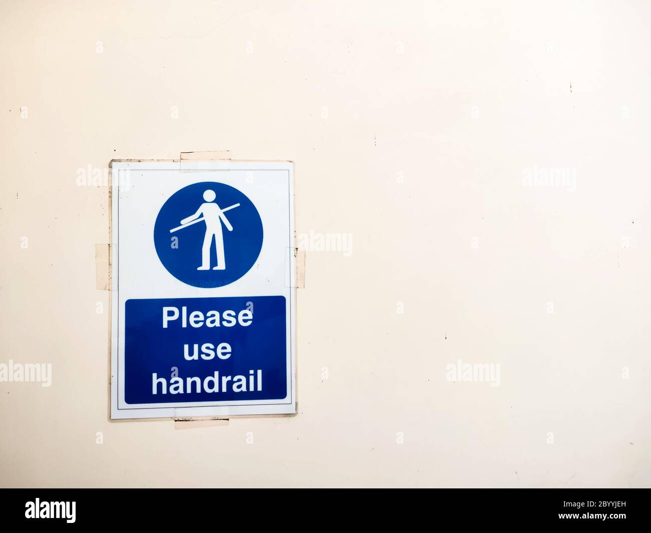 Please use handrail sign poster on wall near escalator. Stock Photo