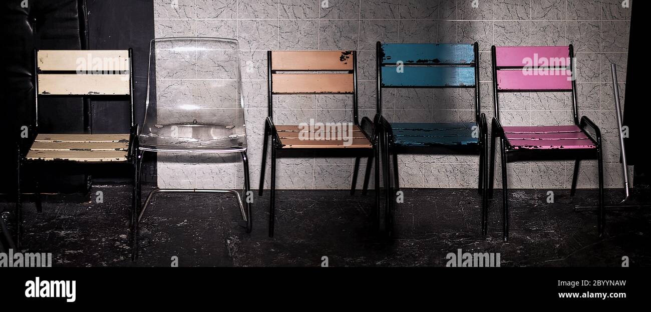 Set of Five old wooden, metal and plastic colored chairs. Business leadership. recruitment concept. The chair in different color can be used as a meta Stock Photo