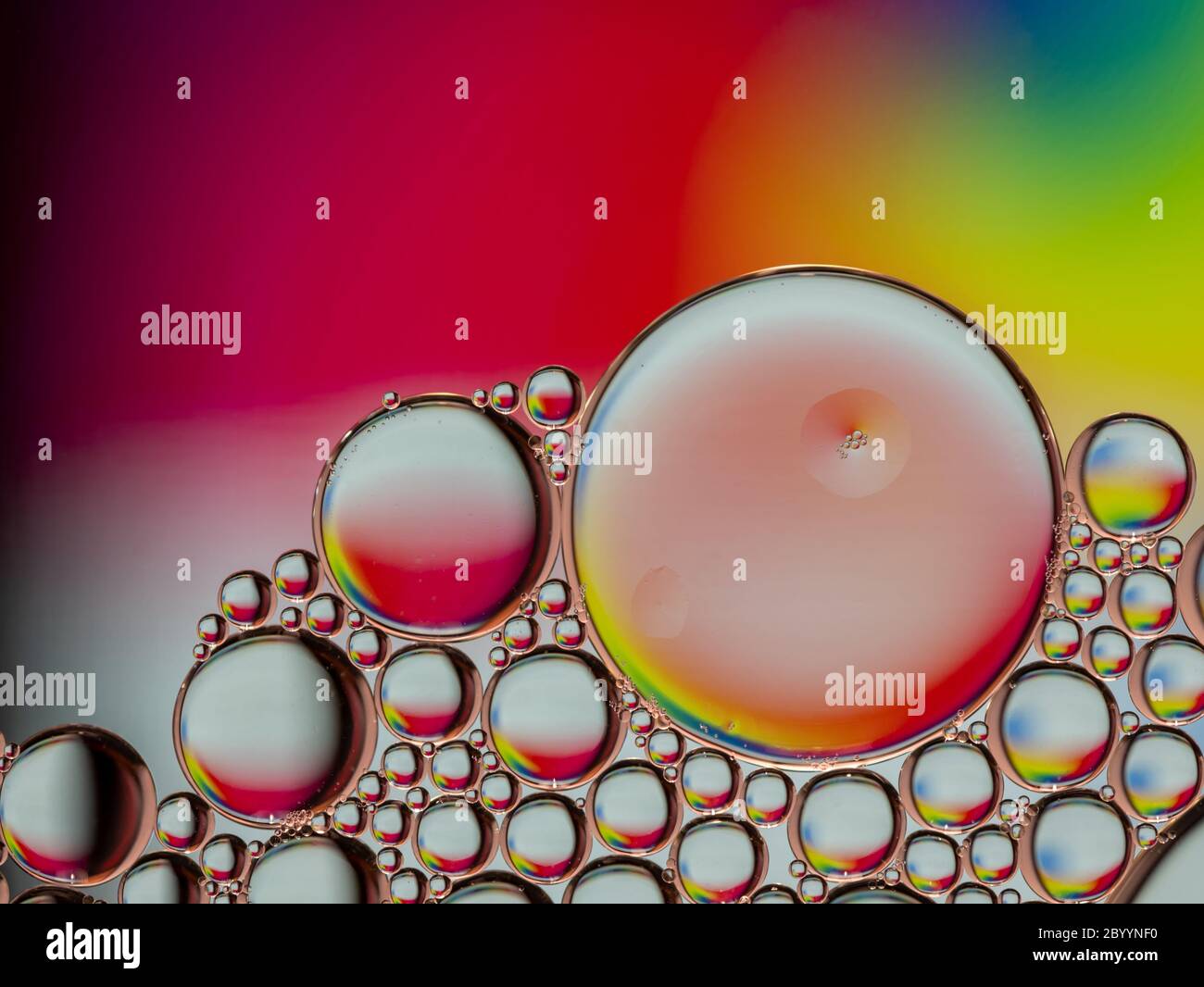 Colorful oil bubbles rimmed in a copper color forming a textured abstract background Stock Photo