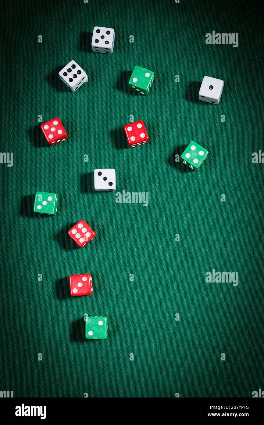 Multi-colored dice on a playing table with green cloth Stock Photo