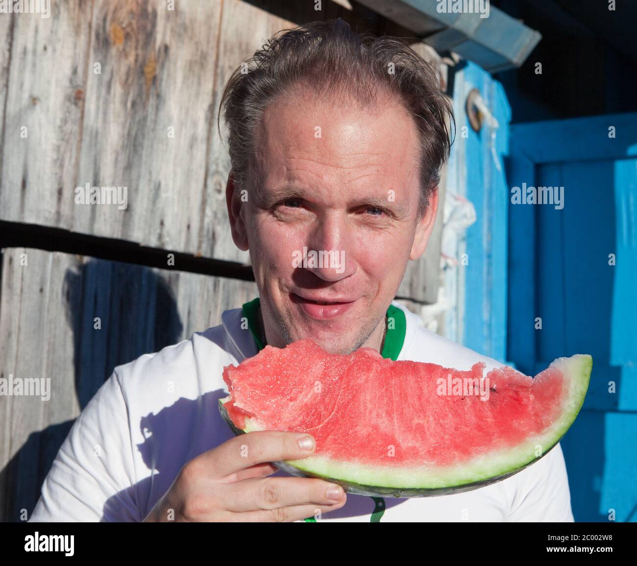 happy man with a piece of a watermelon Stock Photo Alamy