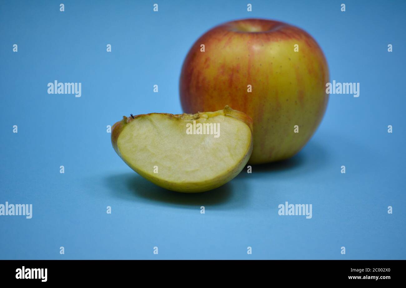 Fresh apple with slice on blue background Stock Photo