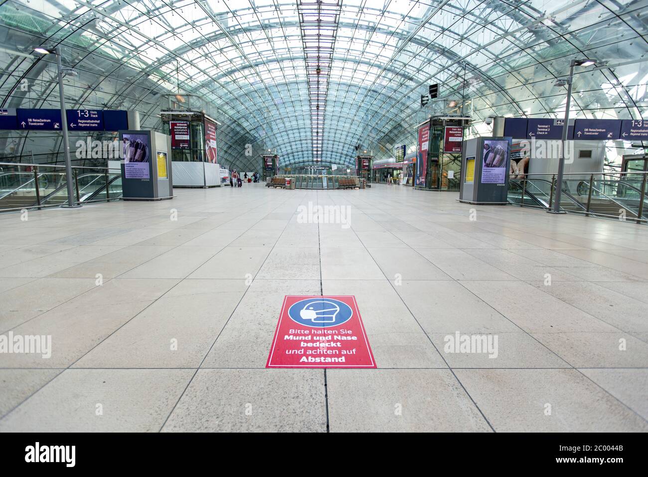 A warning sticker for face masks is glued to the floor inside the nearly empty Frankfurt International Airport during the lockdown caused by the COVID-19 virus. Worldwide, the air traffic industry is heavily impacted by the massive drop in traffic. Stock Photo