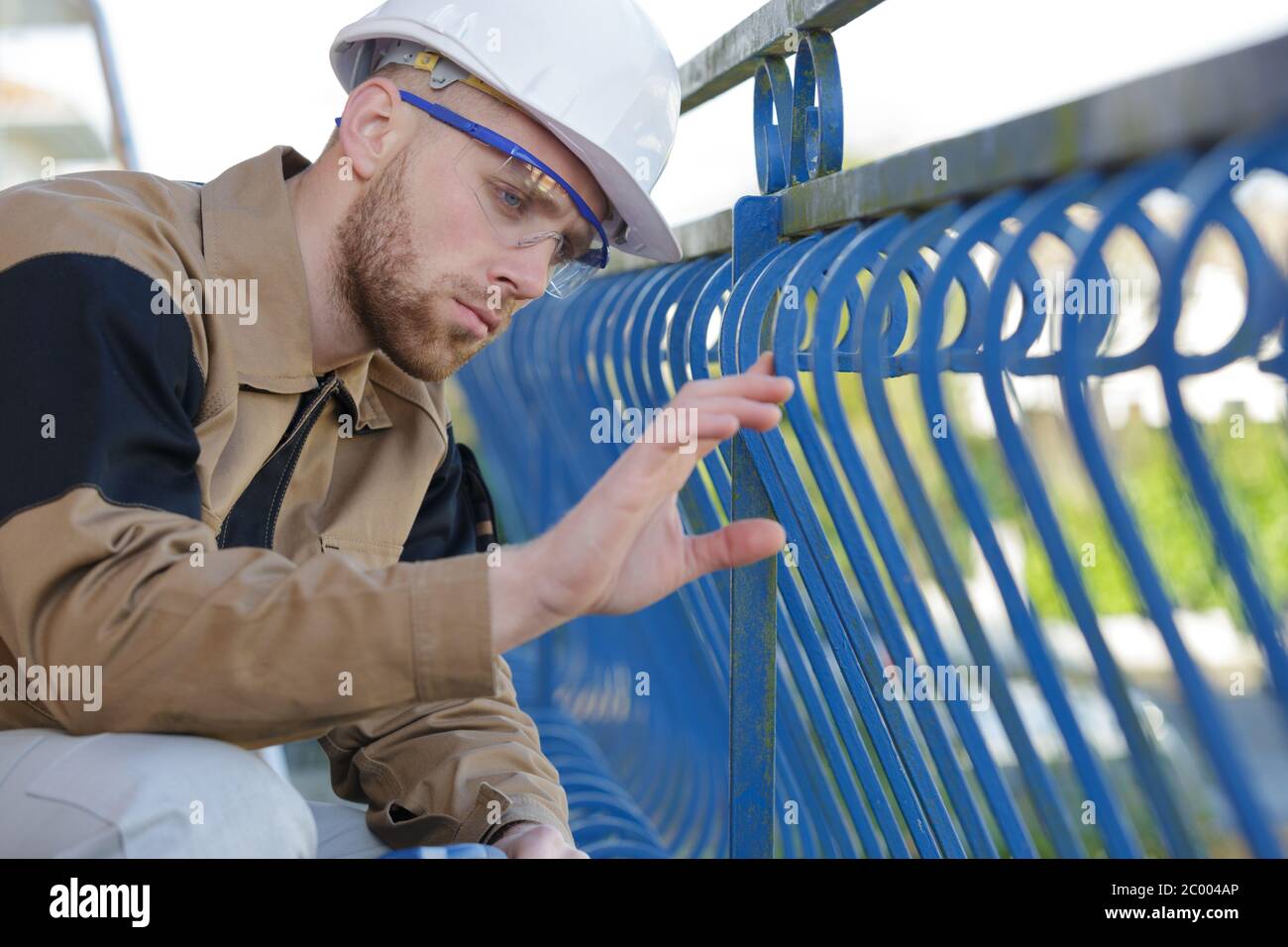 male worker inspecting metal railing Stock Photo - Alamy