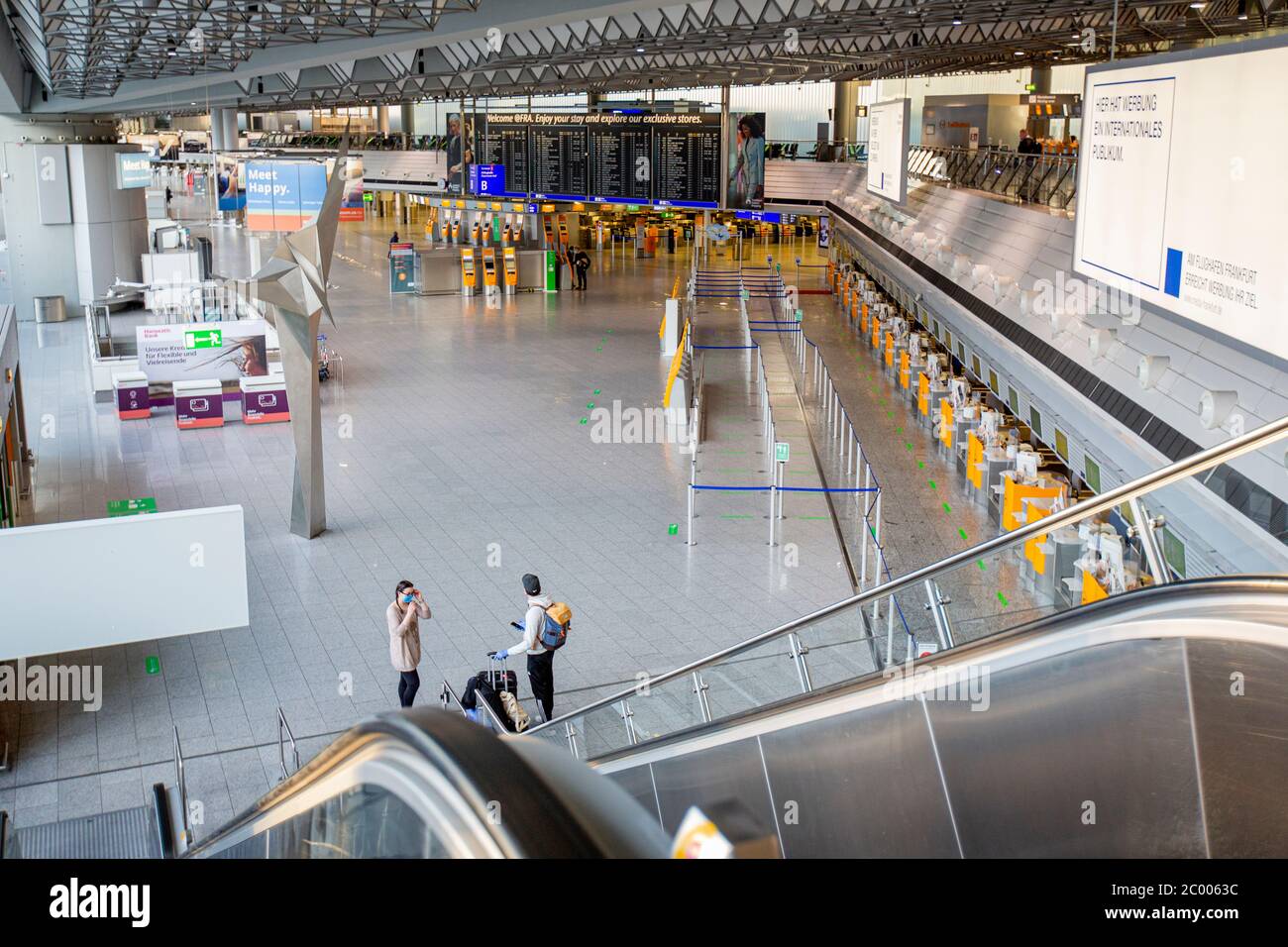 Passengers in the check-in area of the nearly empty Frankfurt Airport during the lockdown caused by the COVID-19 virus. Worldwide, the air traffic industry is heavily impacted by the massive drop in traffic. Stock Photo