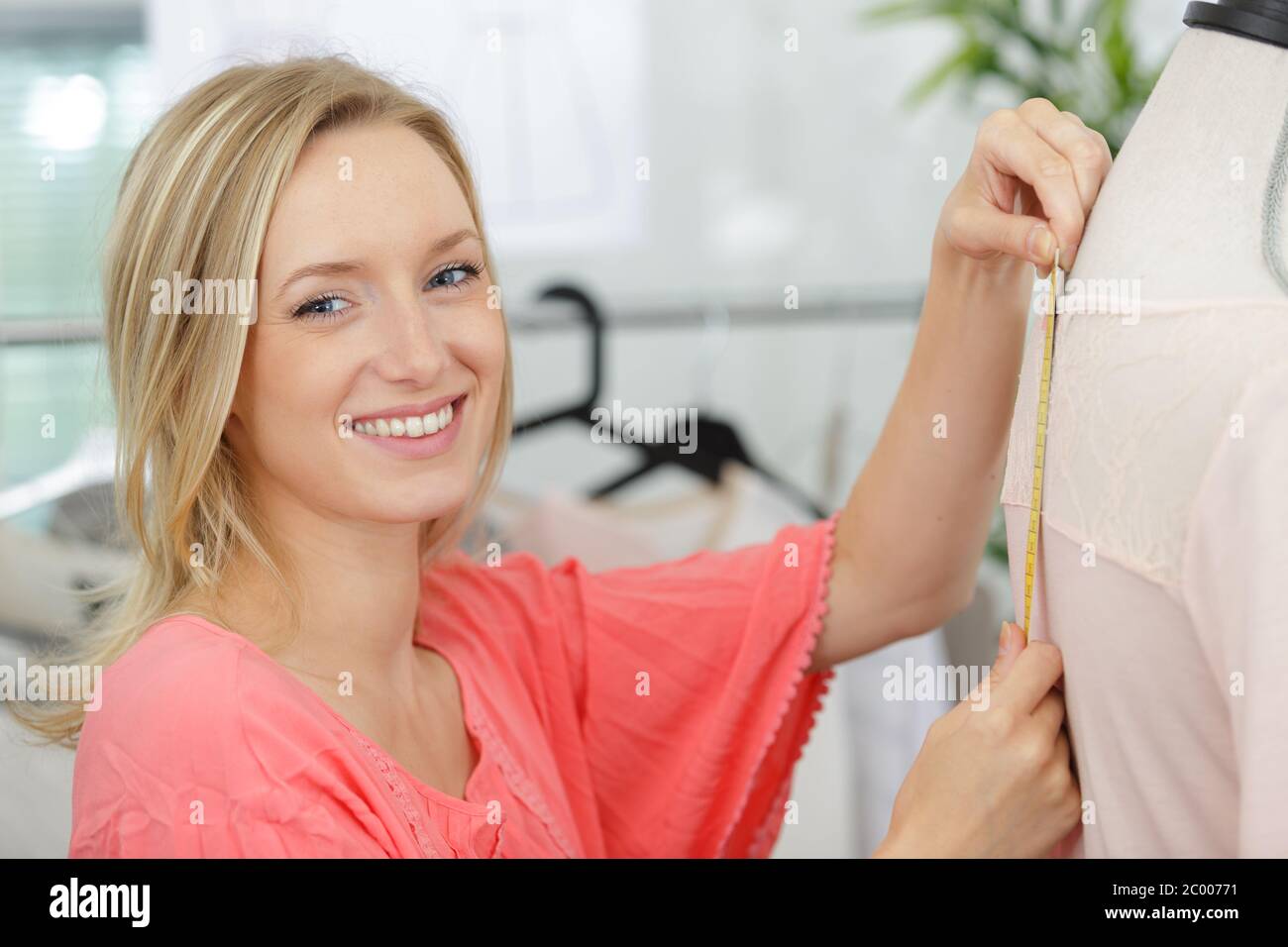 female dressmaker using tape measure on mannequin Stock Photo Alamy