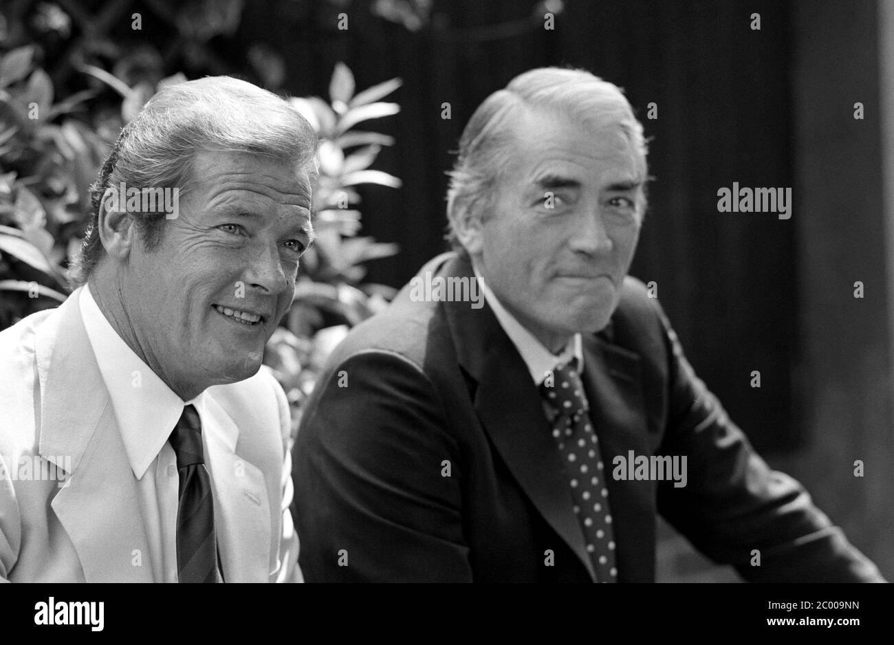 LONDON, UK. Aug 1980: Actors Roger Moore & Gregory Peck at photocall for 'Sea Wolves' at the Inn on the Park Hotel in London. © Paul Smith/Featureflash Stock Photo
