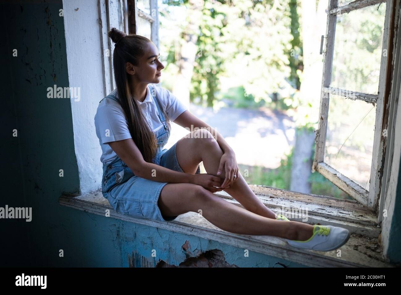 The girl is sad in the ruined house Stock Photo