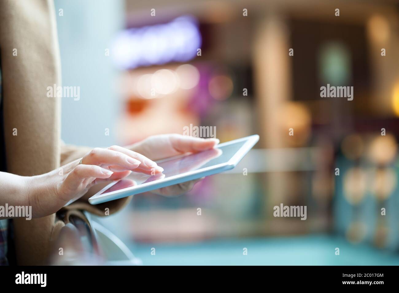 Woman with tablet computer in public place Stock Photo
