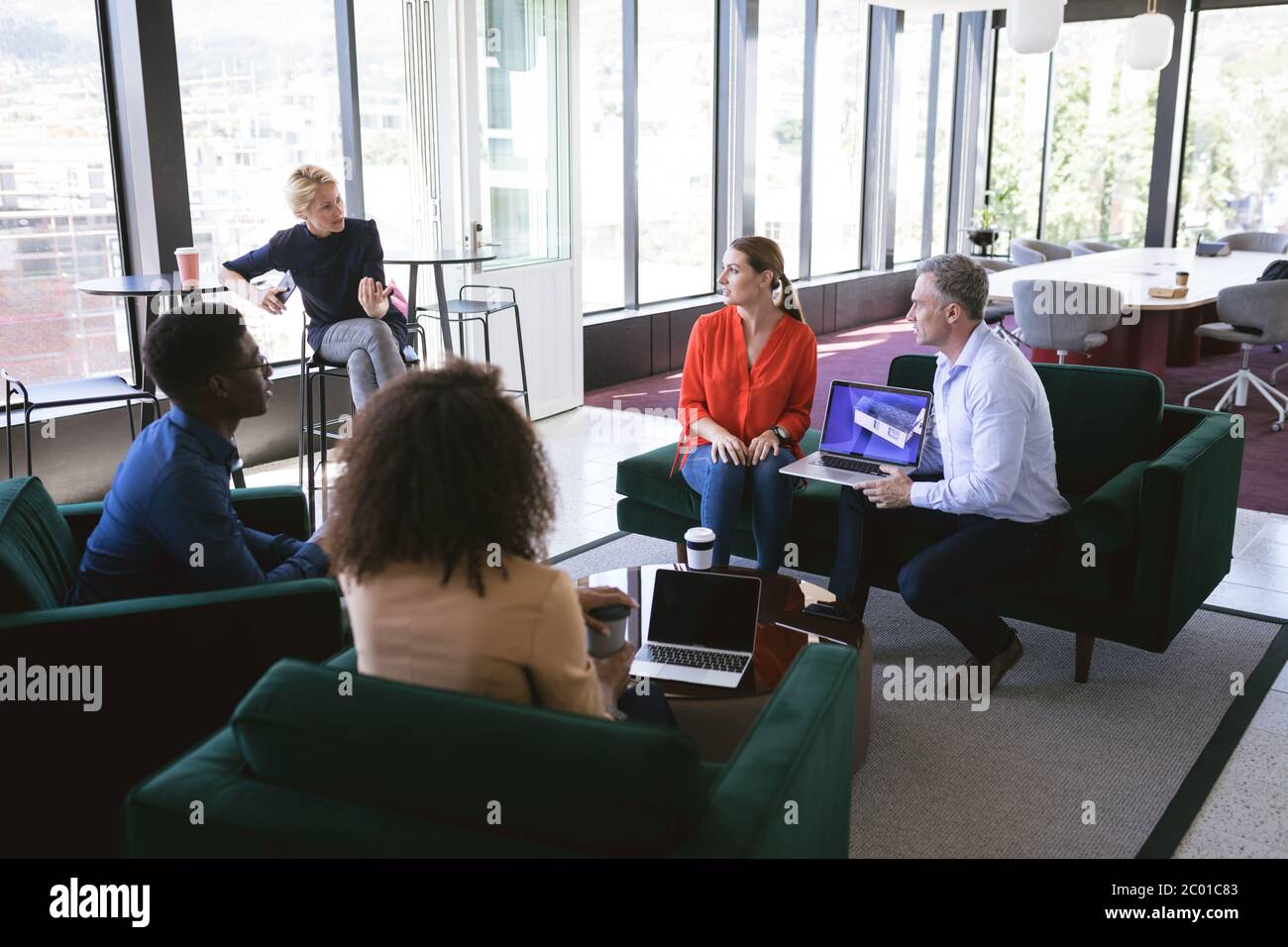 Diverse businesspeople talking in a workspace Stock Photo