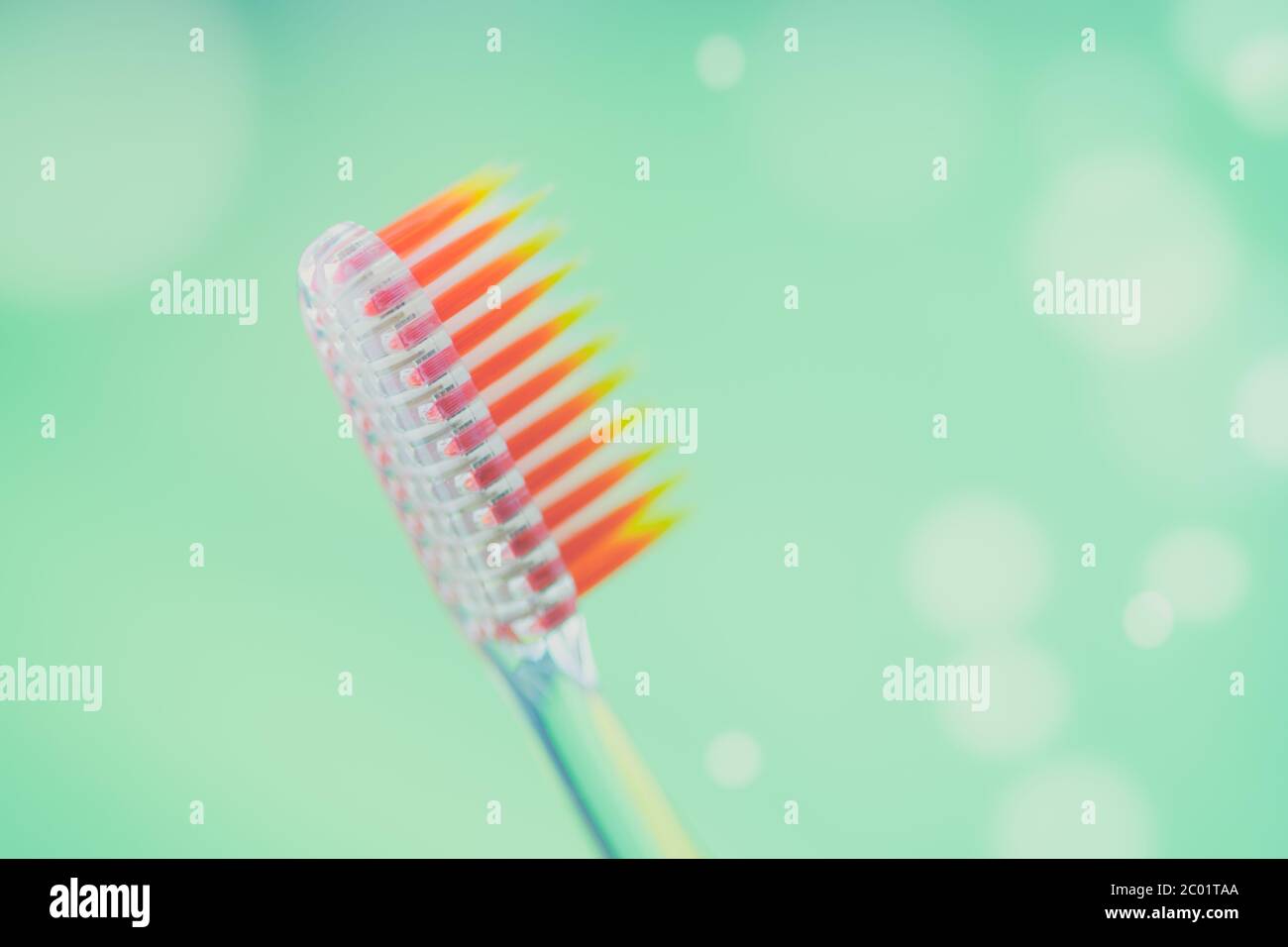 New plastic toothbrush on a green background with bubbles. Stock Photo